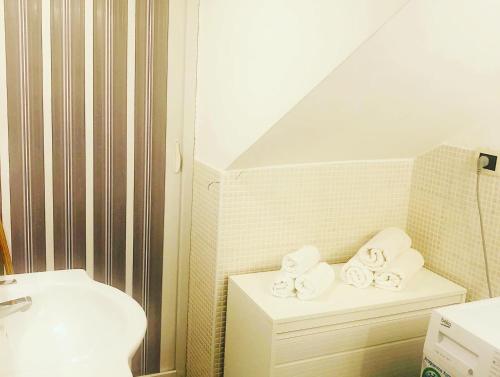 baño con lavabo y una pila de toallas en La casa di Alice è un bilocale luminoso e felice, en Porto Empedocle