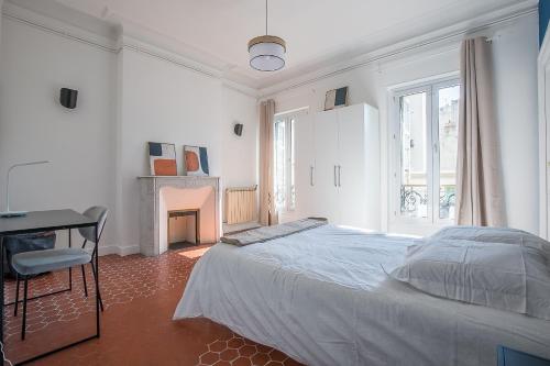 une chambre blanche avec un lit et une cheminée dans l'établissement Superbe Appartement 6CH dans le cœur de Marseille - La French Casa Dragon, à Marseille