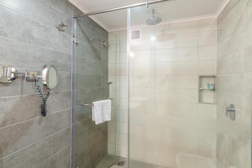 a bathroom with a shower with a glass door at Nairobi Safari Club by Swiss-Belhotel in Nairobi