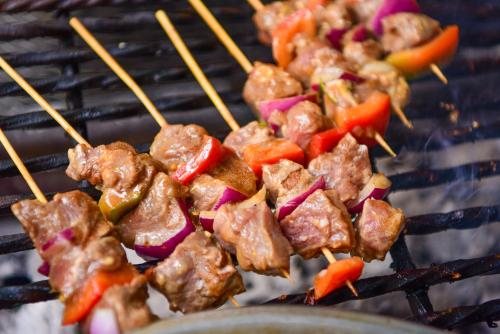 a group of skewers of meat and vegetables on a grill at Nairobi Safari Club by Swiss-Belhotel in Nairobi