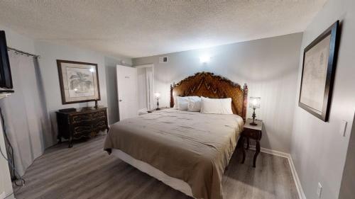 a bedroom with a large bed with a wooden headboard at Moondrifter 101 in Panama City Beach