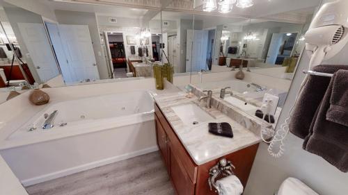 a bathroom with a tub and a large mirror at Moondrifter 101 in Panama City Beach