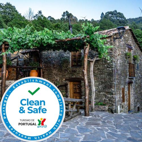 a stone building with a sign that says clean and safe at Montanhas do Xisto - Casa da Eira in Candal