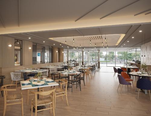 a dining room with tables and chairs and windows at Centara Life Hotel Bangkok Phra Nakhon in Bangkok