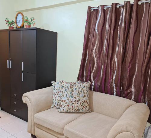 a living room with a couch and a cabinet at Pet Friendly Staycation in in Cainta