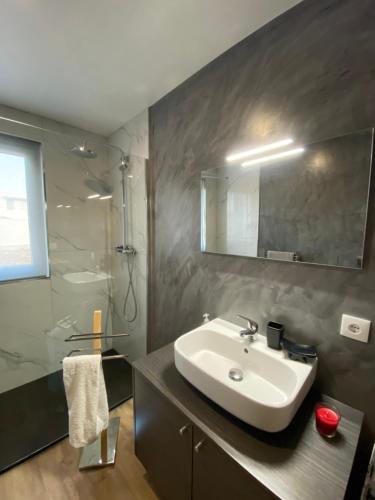La salle de bains est pourvue d'un lavabo, d'une douche et d'un miroir. dans l'établissement Casa Vista Mar, à Castelo do Neiva