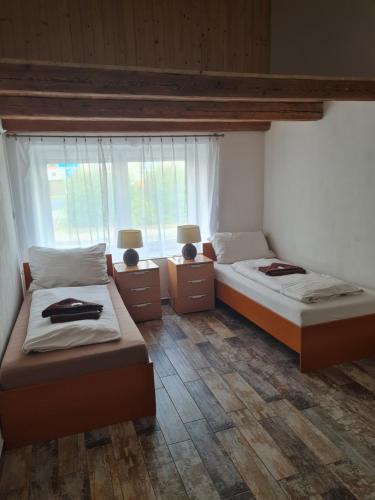 1 dormitorio con 2 camas y ventana en Penzion Alka, en Kaplice