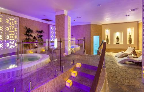 ein Badezimmer mit zwei Waschbecken und einer Badewanne mit violetter Beleuchtung in der Unterkunft GF GRAN COSTA ADEJE***** in Adeje