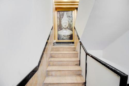a stairway leading up to a statue of a bust at Hotel De Classico Juhu in Mumbai