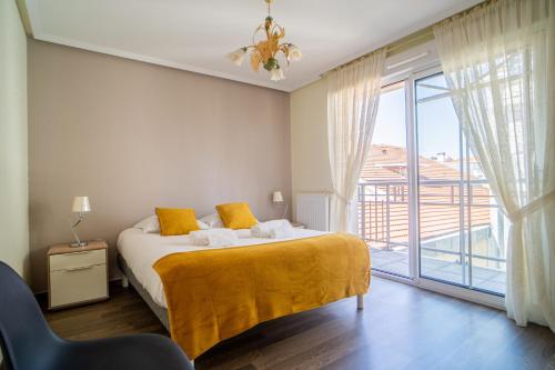 une chambre avec un lit et une grande fenêtre dans l'établissement L'ANDALOU - Bel appartement standing avec terrasses en plein coeur dArcachon, à Arcachon