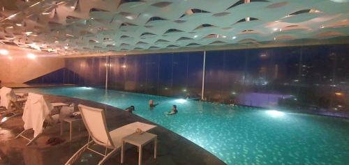 a large swimming pool with people in the water at Joyful Suite at Ion-Delemen Genting Highland in Genting Highlands