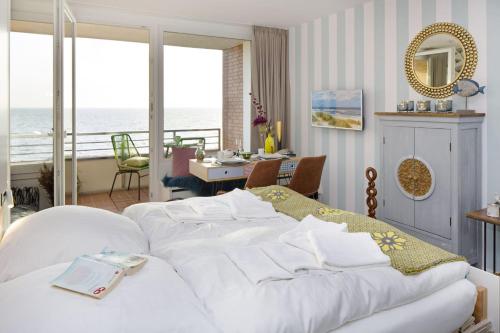 a bedroom with a white bed with a view of the ocean at Lieblingsblick in List