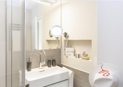 a white bathroom with a sink and a mirror at Lieblingsblick in List