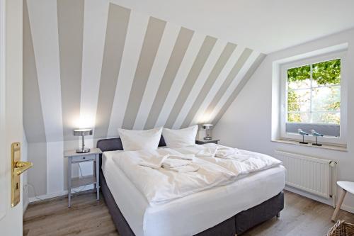 een bed in een kamer met een gestreepte muur bij Hafenblick Haus Senhuk in List