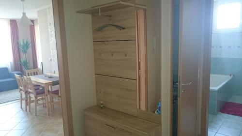 a bathroom with a closet with a wooden door at Réka Apartman in Bük