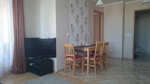 a dining room with a table and chairs and a television at Réka Apartman in Bük