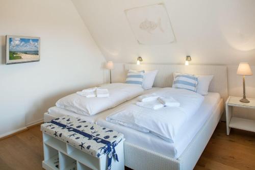 two twin beds in a room with white walls at Strandhaus in List