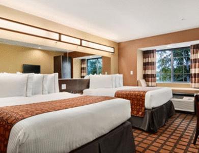 a hotel room with two beds in a room at Microtel Inn & Suites by Wyndham Ozark in Ozark