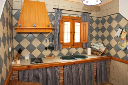 encimera de cocina con fregadero y ventana en El Molino de Batán, en Galera