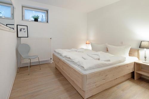 a bedroom with a large bed and a chair at Cap Blanco in List
