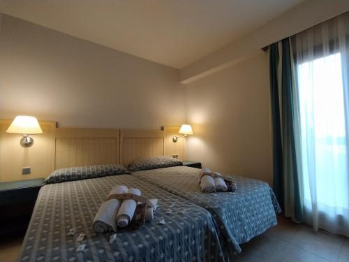 dwa łóżka w pokoju hotelowym z ręcznikami na nich w obiekcie DOS DORMITORIOS CON TRES TERRAZAS EN CUARTA PLANTa w mieście Isla Canela