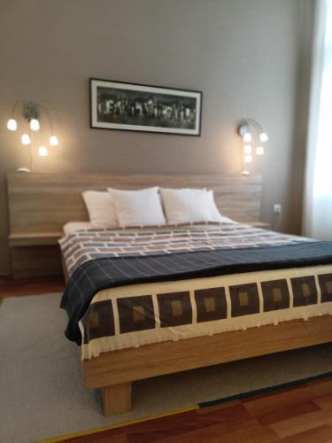 un letto con struttura in legno in una stanza di Evergreen a Belgrado