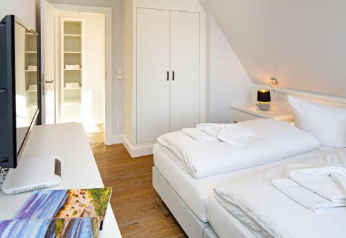 a bedroom with two beds and a desk with a computer at Sunset in List