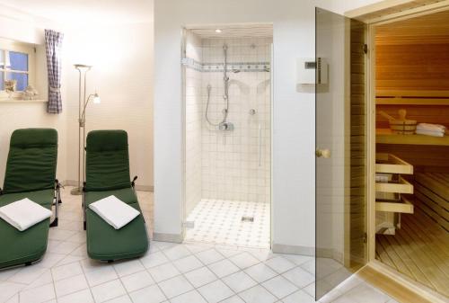 uma casa de banho com cadeiras verdes e um chuveiro em Senenskiin em List