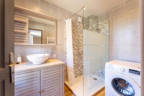une salle de bain avec un lavabo et une machine à laver dans l'établissement Mon Cottin dans le Vexin, à Heudicourt