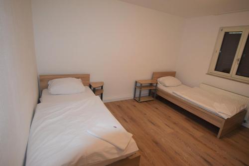 Cette petite chambre comprend 2 lits et une fenêtre. dans l'établissement AB Apartment Objekt 09, à Stuttgart