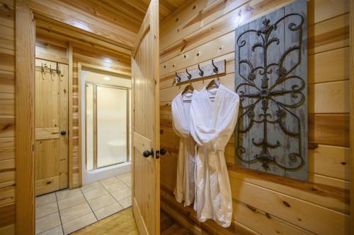 a bathroom with wooden walls and a door with a robe at Shear Pleasure in Broken Bow