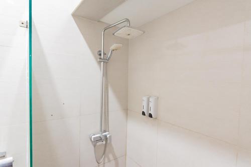 a shower with a glass door in a bathroom at RedDoorz Plus @ Point Phila Cihampelas in Bandung