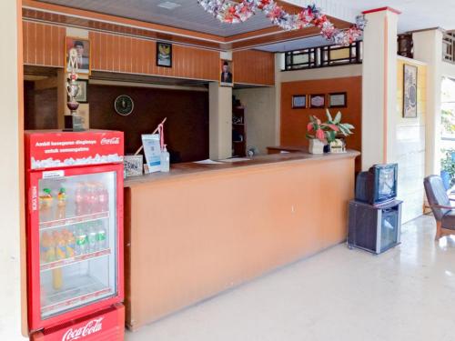 a coca cola machine in front of a counter at RedDoorz near Politeknik Perkeretaapian Indonesia Madiun in Madiun
