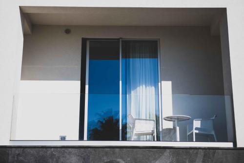 a balcony with a table and chairs on a building at MARINO WELLNESS in Ali Terme