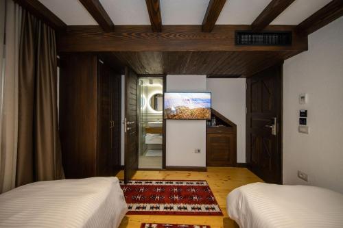 a bedroom with two beds and a painting on the wall at Hotel - Kulla e Zenel Beut in Peje