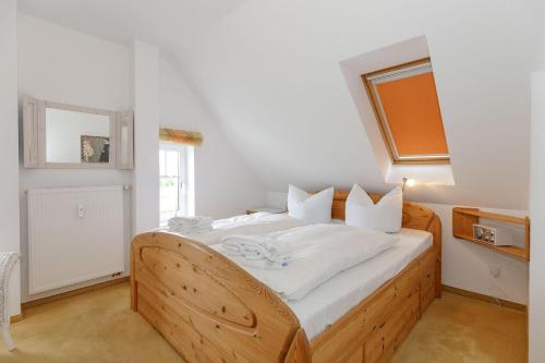 キュールングスボルンにあるHaus-Rolandseck-Wohnung-11-416のベッドルーム1室(白いシーツが備わる木製ベッド1台付)