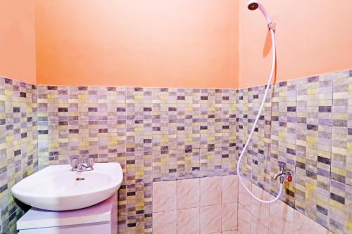 a bathroom with a sink and a shower at OYO 91408 Kas Residence Syariah in Jambi