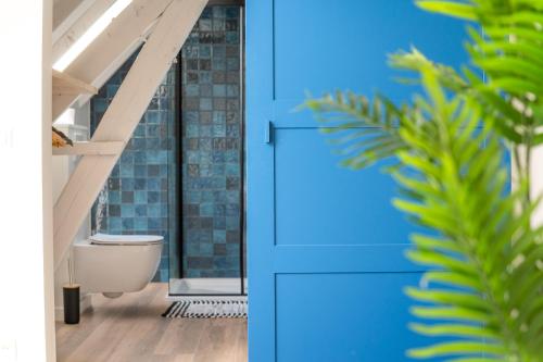 łazienka z niebieskimi drzwiami i toaletą w obiekcie Farmhouse Hoeve Den Ast 5 separate bedrooms with bathrooms w mieście Harelbeke