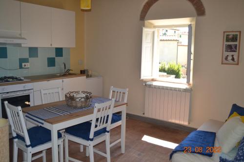 una cucina e una sala da pranzo con tavolo e sedie di La casa di Agata a Guardistallo