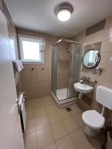 a bathroom with a shower and a toilet and a sink at SKI KUCA PALE in Pale