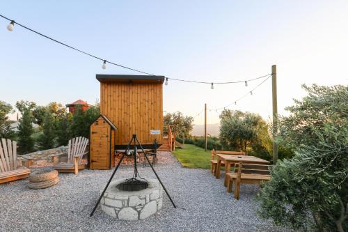 a small wooden cabin with a fire pit and benches at Urlachi Çiftliği in Urla