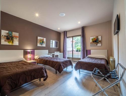 a hotel room with two beds and a window at Hotel Marrodan in Arnedillo