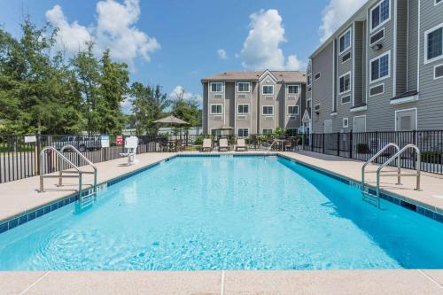 a swimming pool in front of a building at Microtel Inn & Suites by Wyndham Jacksonville Airport in Jacksonville