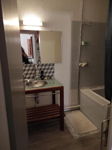 une salle de bain avec un lavabo, un miroir et une baignoire dans l'établissement Le refuge des Gentianes, à Besse-et-Saint-Anastaise