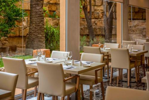 um restaurante com mesas e cadeiras e uma grande janela em Valentin Reina Paguera - Adults Only em Paguera