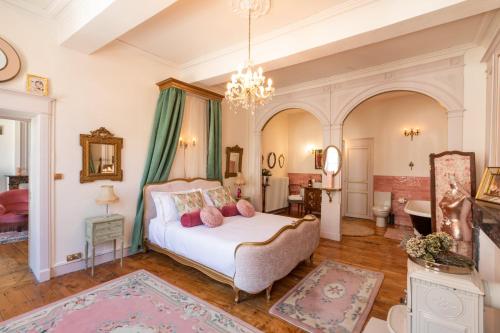 1 dormitorio con cama y lámpara de araña en Luxueuses Suites & Chambres d'hôtes - accueil champagne, petit-déjeuner - Maison Champagne, en Condom