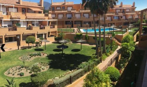 un complexe d'appartements avec un jardin et une piscine dans l'établissement Apartamento con gran terraza a 50 m de la playa, à San Luis de Sabinillas