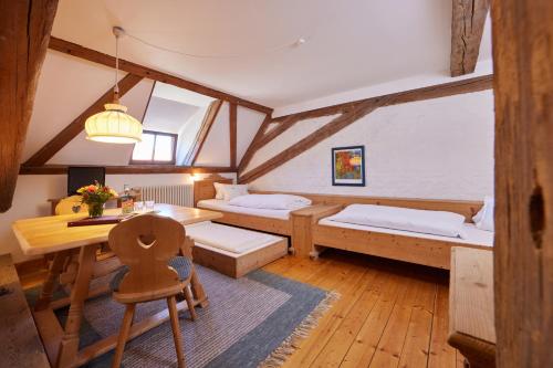 ベネディクトボイアーンにあるZentrum für Umwelt und Kultur - Gästehaus und Jugendbildungseinrichtung im Maierhofのベッドが2つと机とテーブルがある部屋