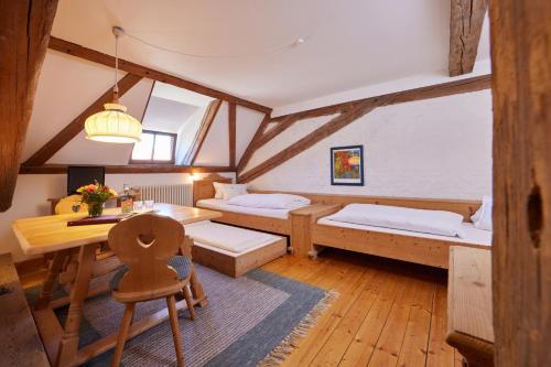 a room with two beds and a desk and a table at Zentrum für Umwelt und Kultur - Gästehaus und Jugendbildungseinrichtung im Maierhof in Benediktbeuern