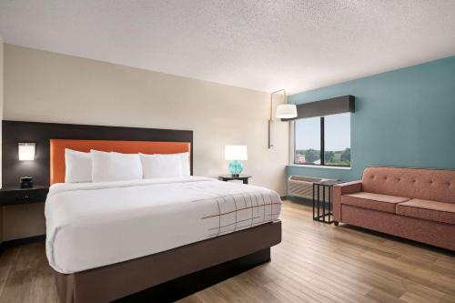 a hotel room with a large bed and a couch at La Quinta Inn by Wyndham Columbus Dublin in Dublin